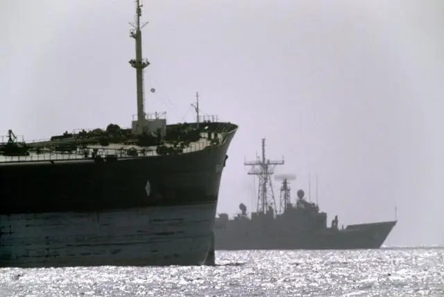 سفينة حربية أمريكية في الخلفية تبحر بجانب سفينة شحن خلال عملية إرنست ويل في مضيق هرمز.