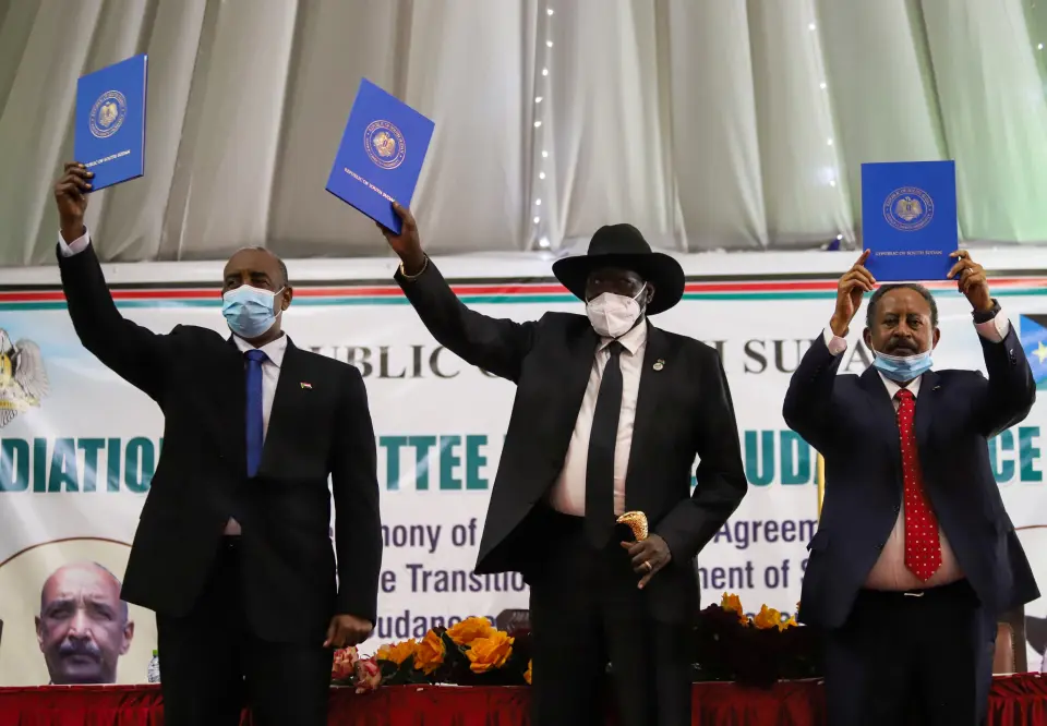 Sudan's Sovereign Council Chief General Abdel Fattah al-Burhan, South Sudan's President Salva Kiir and Sudan's Prime Minister Abdalla Hamdok lift copies of a signed peace agreement with the country's five key rebel groups in Juba